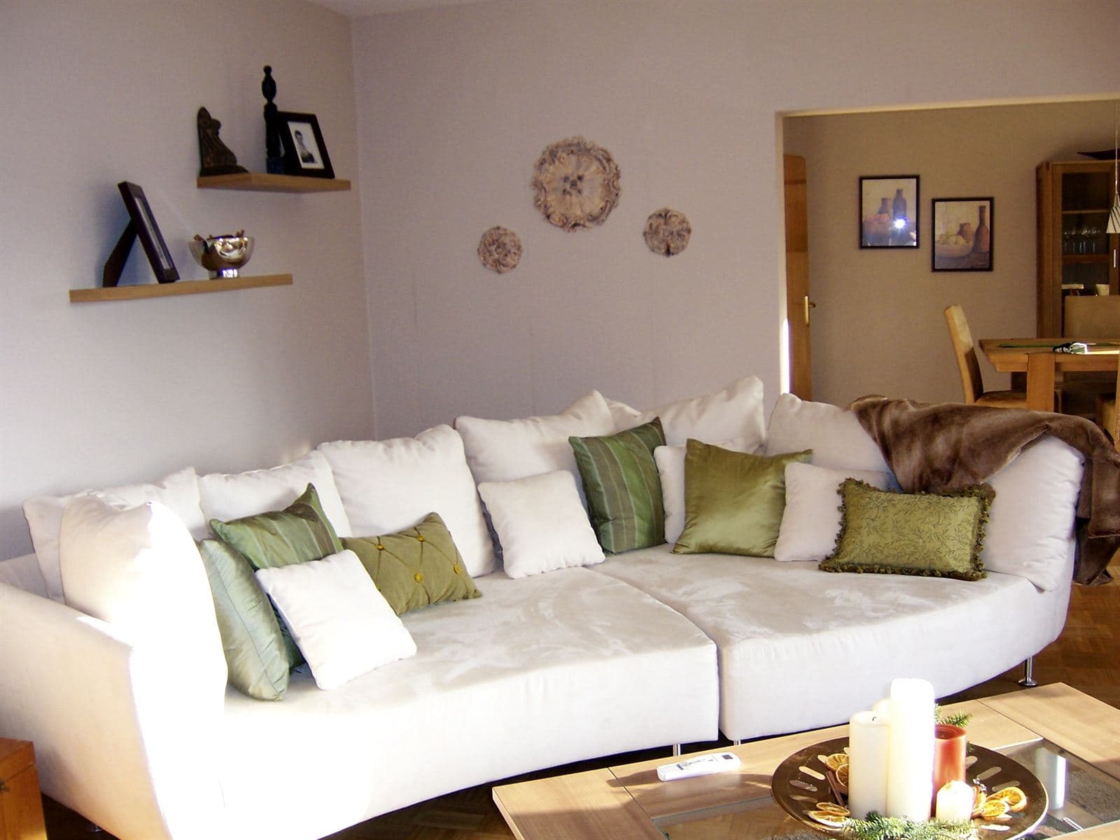 Bright living room with a white sofa and green cushions